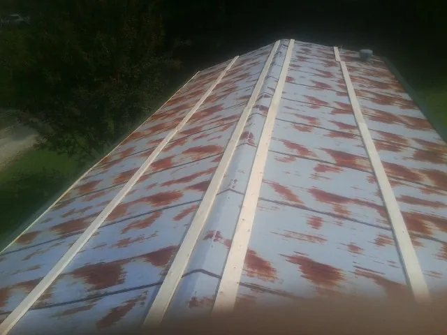 Rusted metal roof panels with new wood purlins before replacement — Storm Damage Roof Repair in Coloma by Roofing Brothers