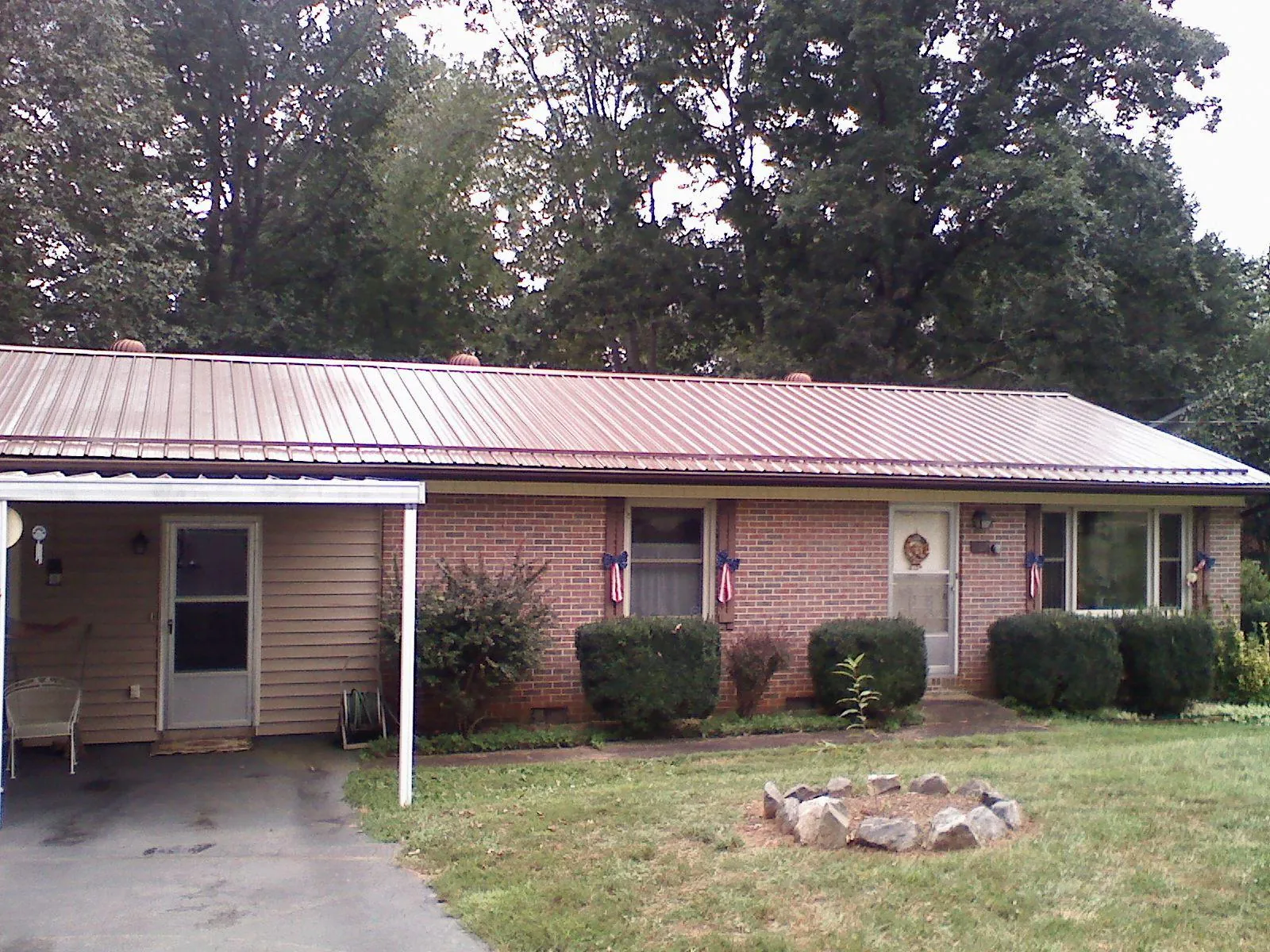 Bronze metal roof and carport on a brick ranch home — Roof Repair work by our crew in Coloma
